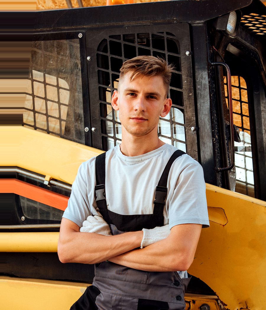 A young agricultural worker beside farm equipment